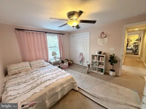 a bedroom with a bed gym equipment and a large window