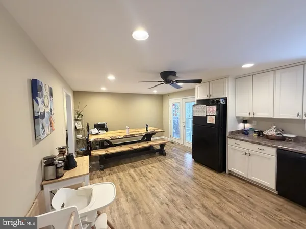 a kitchen with stainless steel appliances kitchen island granite countertop a refrigerator a sink a stove and a wooden floors