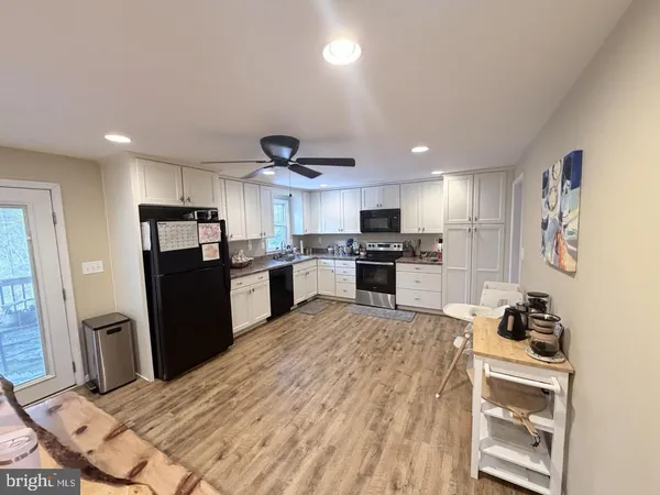 a kitchen with stainless steel appliances kitchen island granite countertop a refrigerator stove microwave and sink