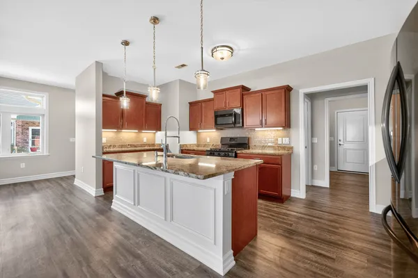 a living room with furniture kitchen view and a large window
