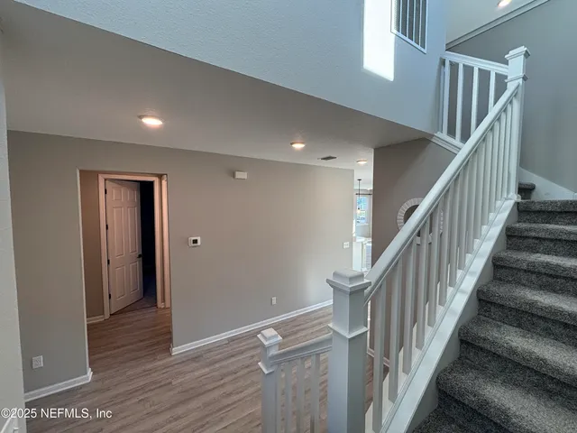 a large kitchen with stainless steel appliances kitchen island a large counter top and a wooden floors