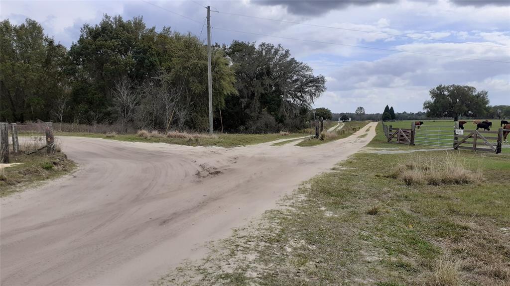 a view of a dirt road with a building in the background