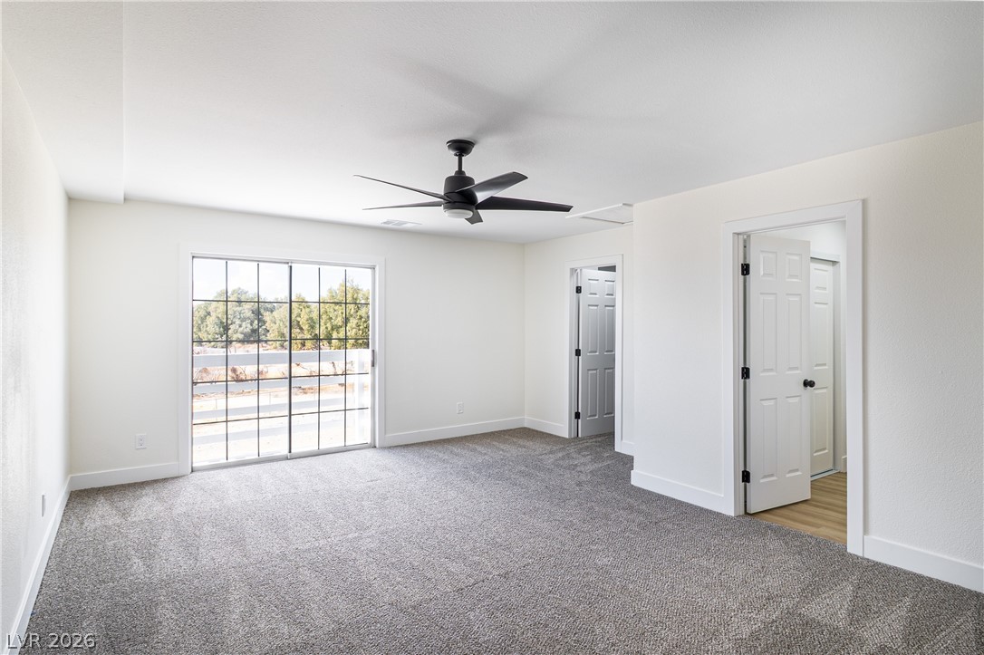 1891 Brian Road Pahrump, NV 89048 - Photo 35 of 50 Unfurnished bedroom with baseboards, carpet, and access to exterior