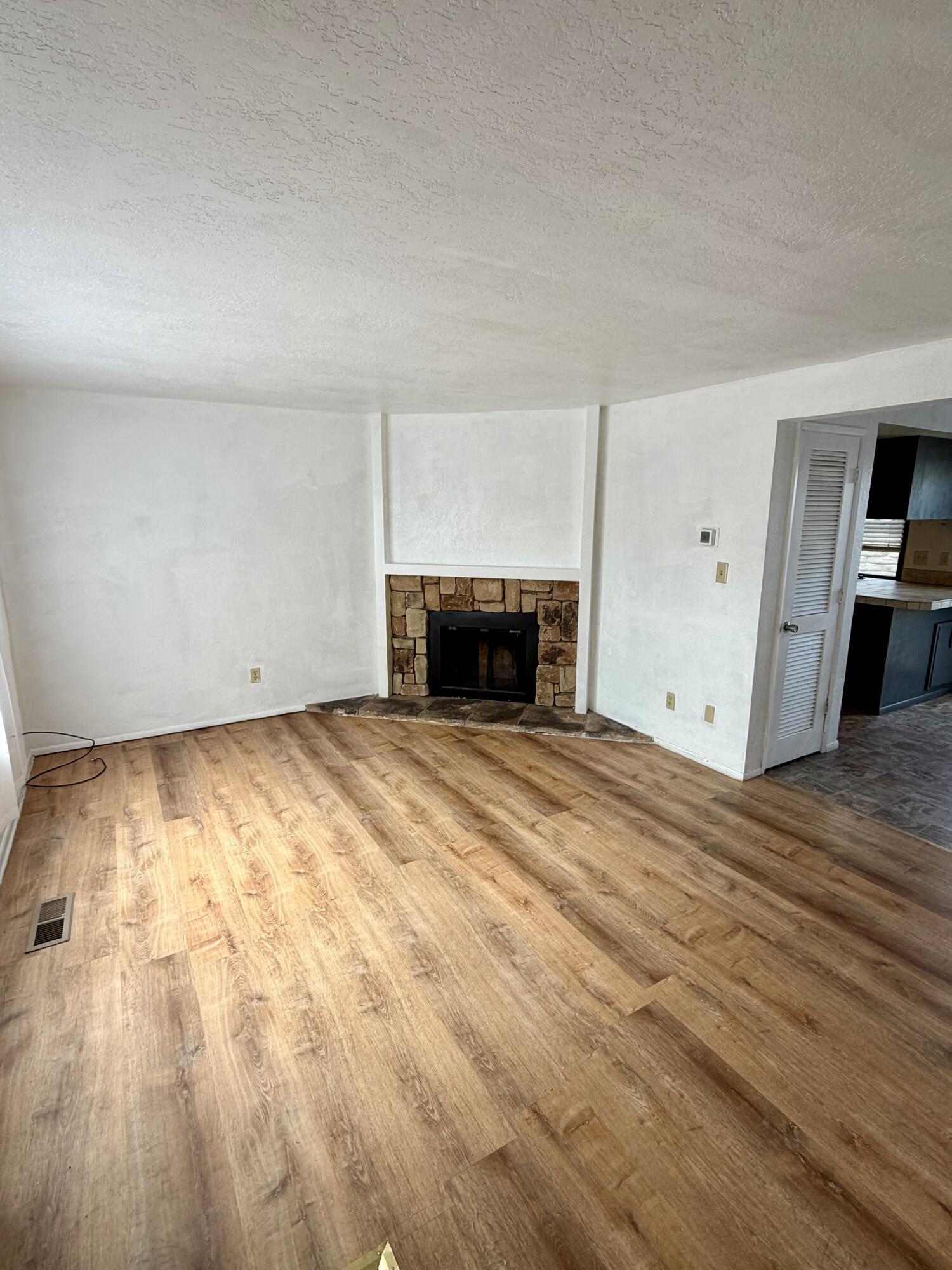 1198 Morrow Road, Unit A Medford, OR 97504 - Photo 3 of 20 a view of empty room with wooden floor and fireplace