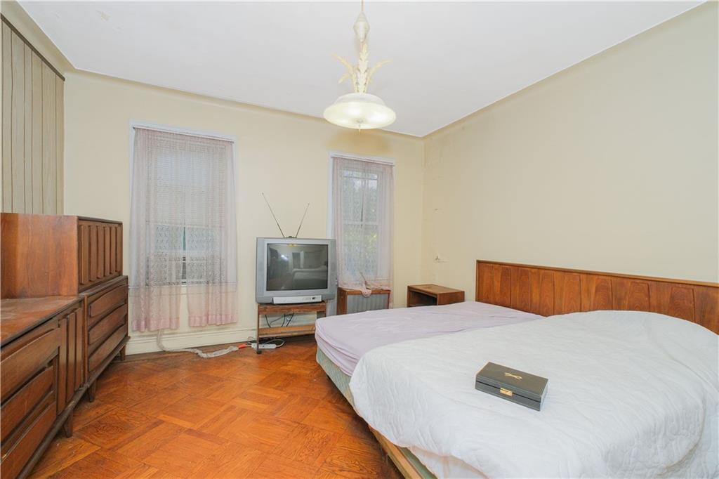 660 85th Street Brooklyn, NY 11228 - Photo 16 of 32 a bedroom with a bed and a flat screen tv