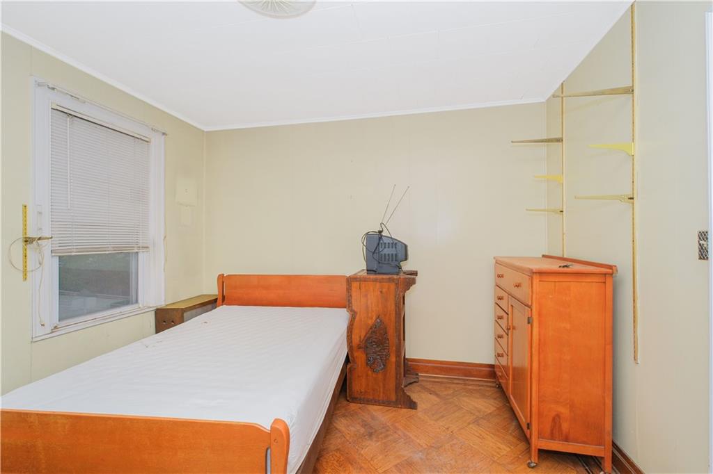 660 85th Street Brooklyn, NY 11228 - Photo 22 of 32 a bedroom with a bed and wooden floor