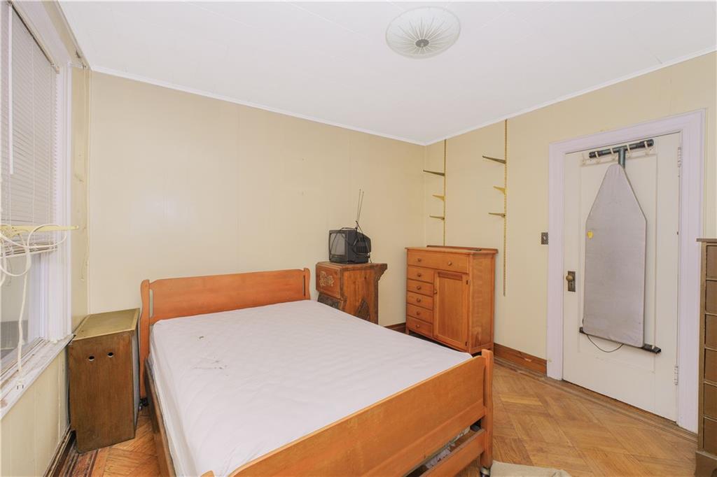 660 85th Street Brooklyn, NY 11228 - Photo 24 of 32 a bedroom with a bed and wooden floor