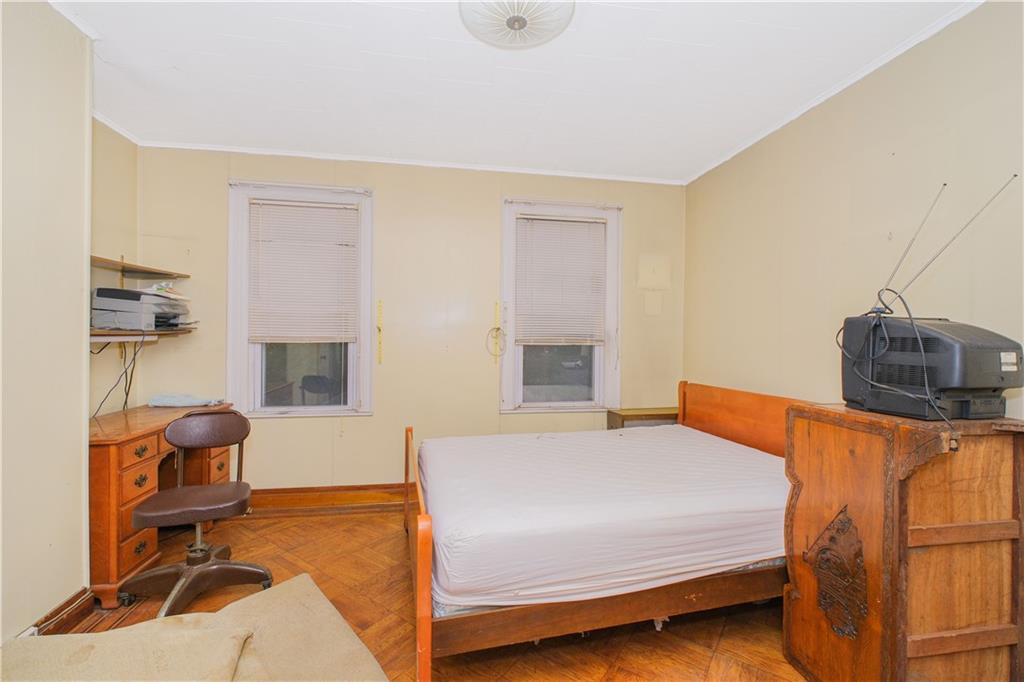 660 85th Street Brooklyn, NY 11228 - Photo 25 of 32 a bedroom with a bed and chair