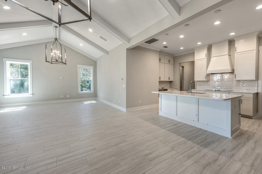 434 Ridgeway Road St. Augustine Beach, FL 32080 - Photo 6 of 23 a large kitchen with kitchen island a sink dishwasher a stove and white cabinets with wooden floor