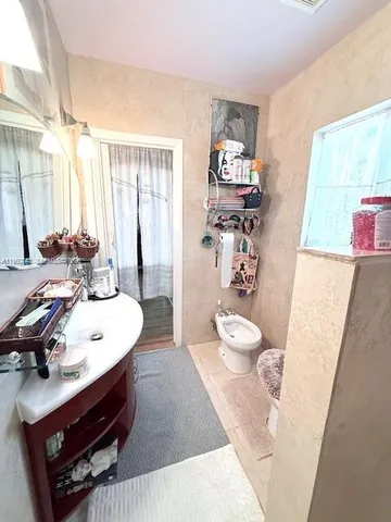 a bathroom with a sink a toilet and a large mirror