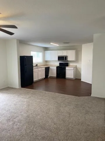 a view of kitchen with refrigerator stove microwave and cabinets