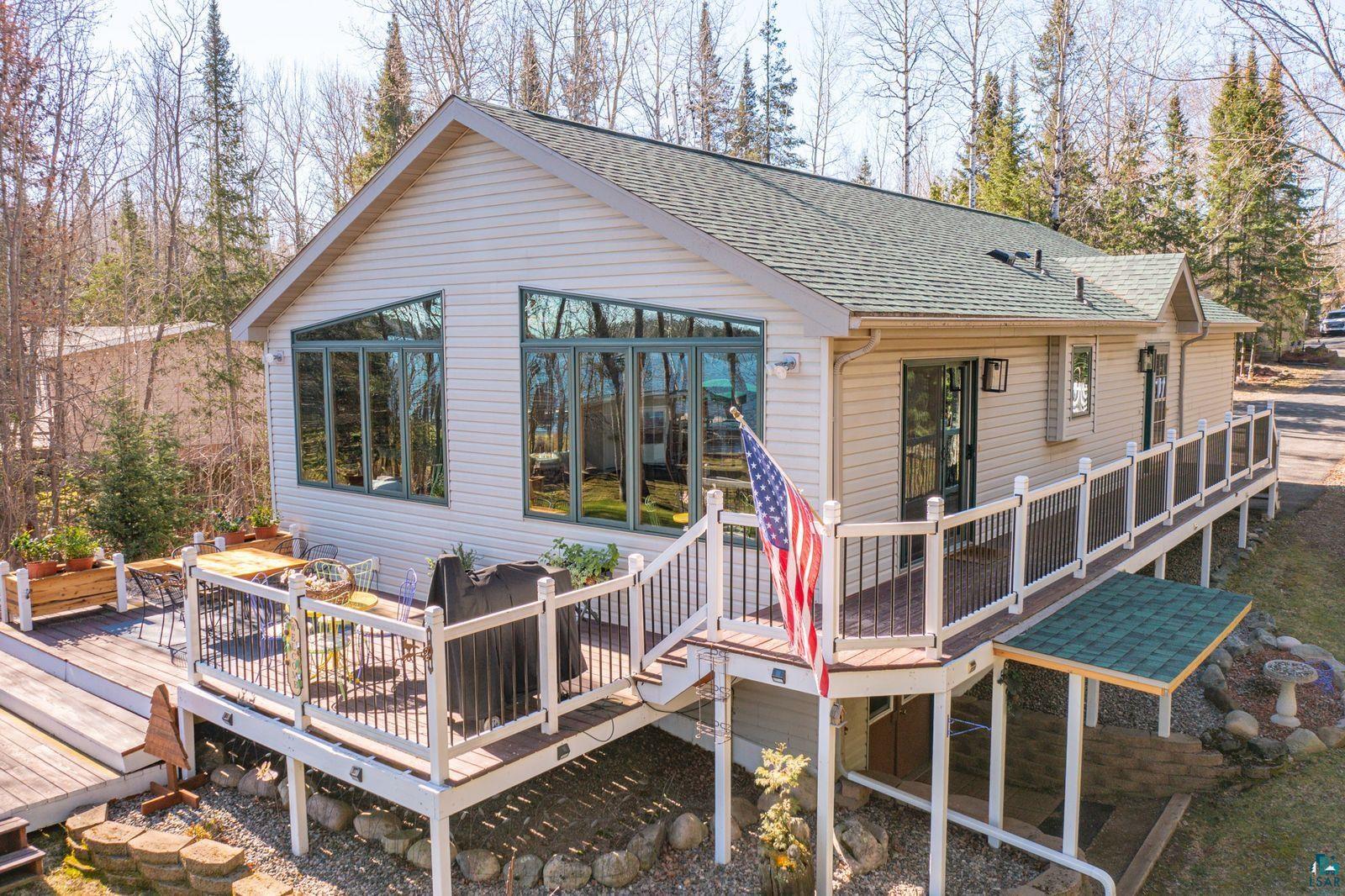 4452 Moccasin Point Road Tower, MN 55790 - Photo 2 of 44 Spacious wood-finish deck featuring white railings with black balusters and multiple entry points