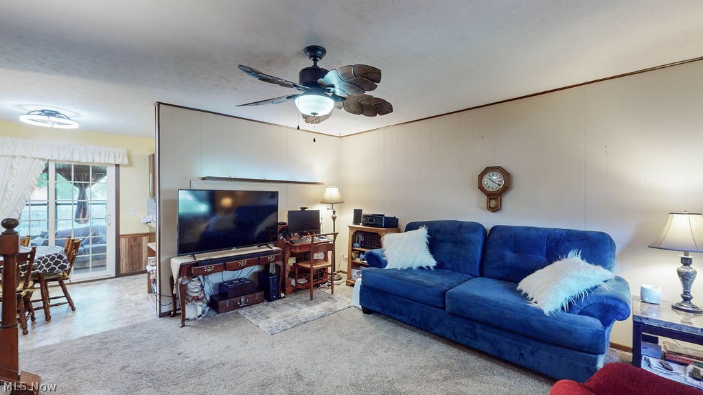 38667 Chestnut Ridge Road Elyria, OH 44035 - Photo 7 of 35 Carpeted living area featuring a ceiling fan with light fixture, light-toned walls, and an open layout to an adjoining dining space