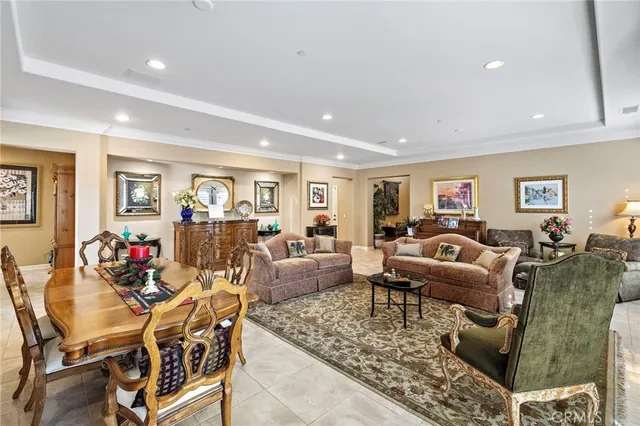 a living room with couches and kitchen view with wooden floor
