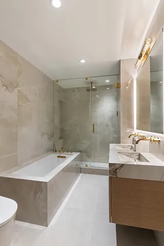 a bathroom with a bathtub a sink a toilet and a mirror