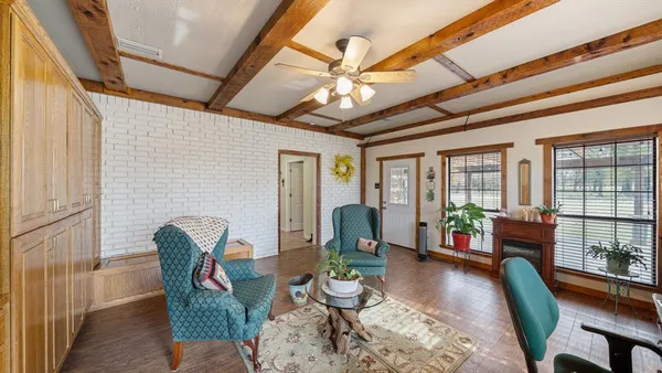 a living room with furniture floor to ceiling window and wooden floor