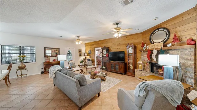 a living room with furniture kitchen view and a flat screen tv