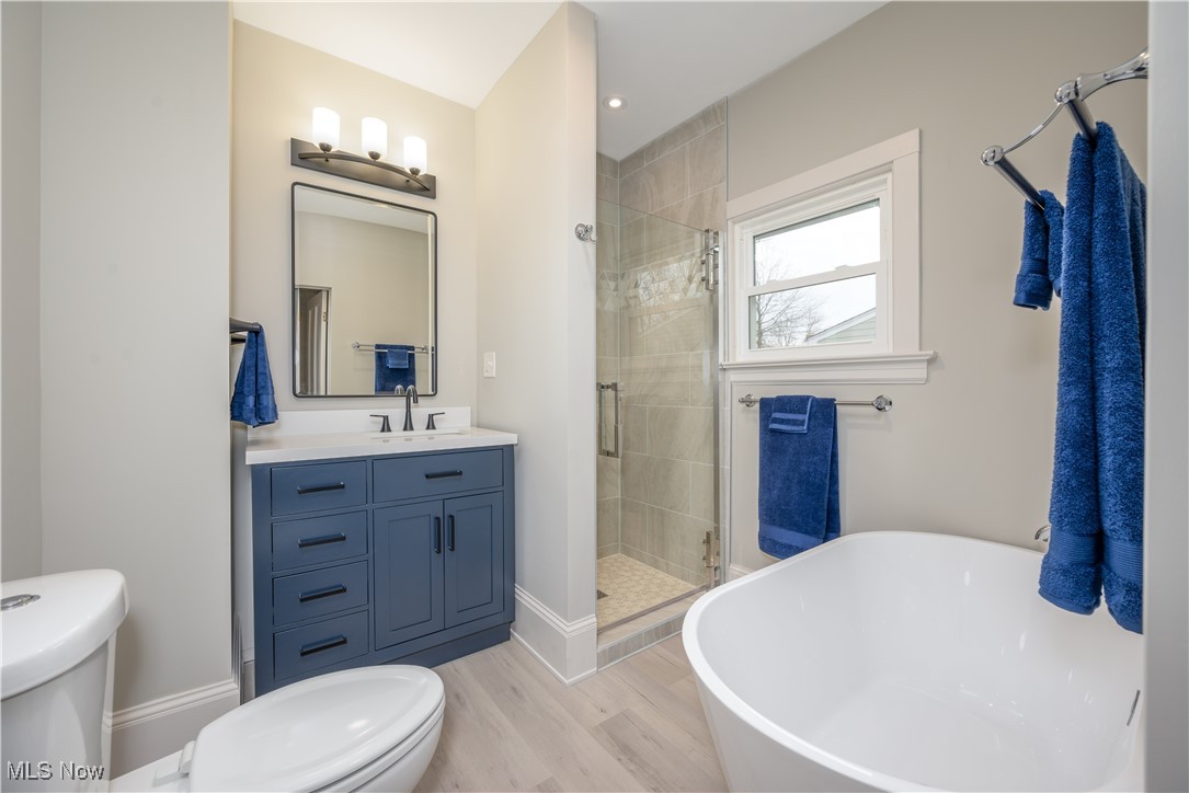 17728 Windward Road Cleveland, OH 44119 - Photo 22 of 32 Full bathroom with toilet, wood-type flooring, shower with separate bathtub, and vanity