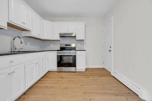 a kitchen with stainless steel appliances granite countertop a sink and cabinets with wooden floors