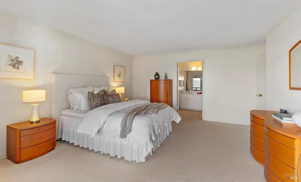 a spacious bedroom with a bed and a lamp