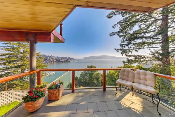 a view of two chairs and table in the balcony