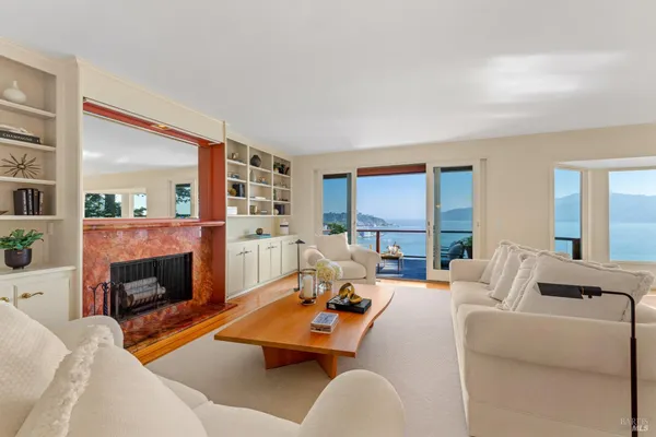 a living room with furniture fireplace and a large window