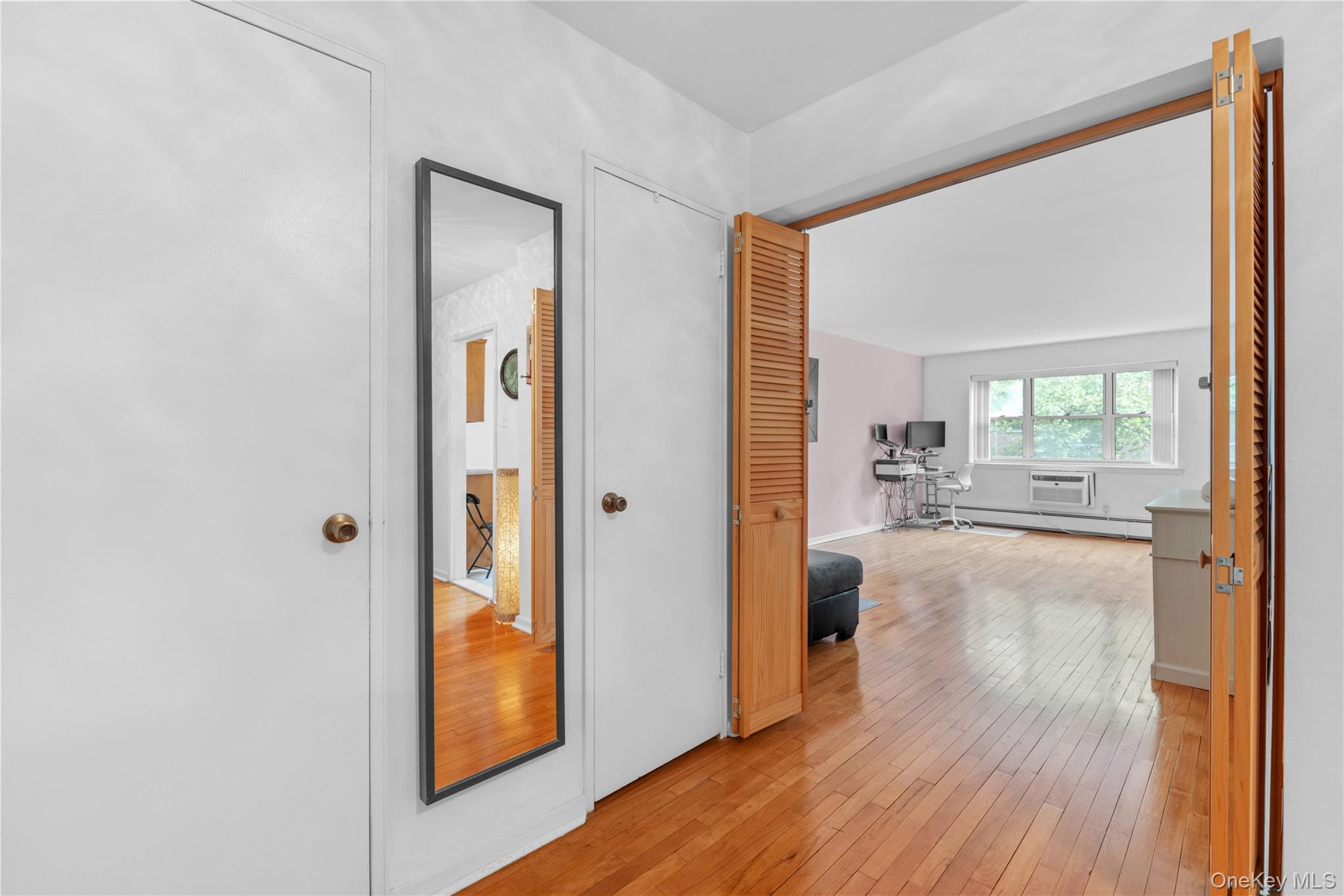 99-10 60th Avenue, Unit 3B Queens, NY 11368 - Photo 7 of 27 a view of a hallway with wooden floor and a living room
