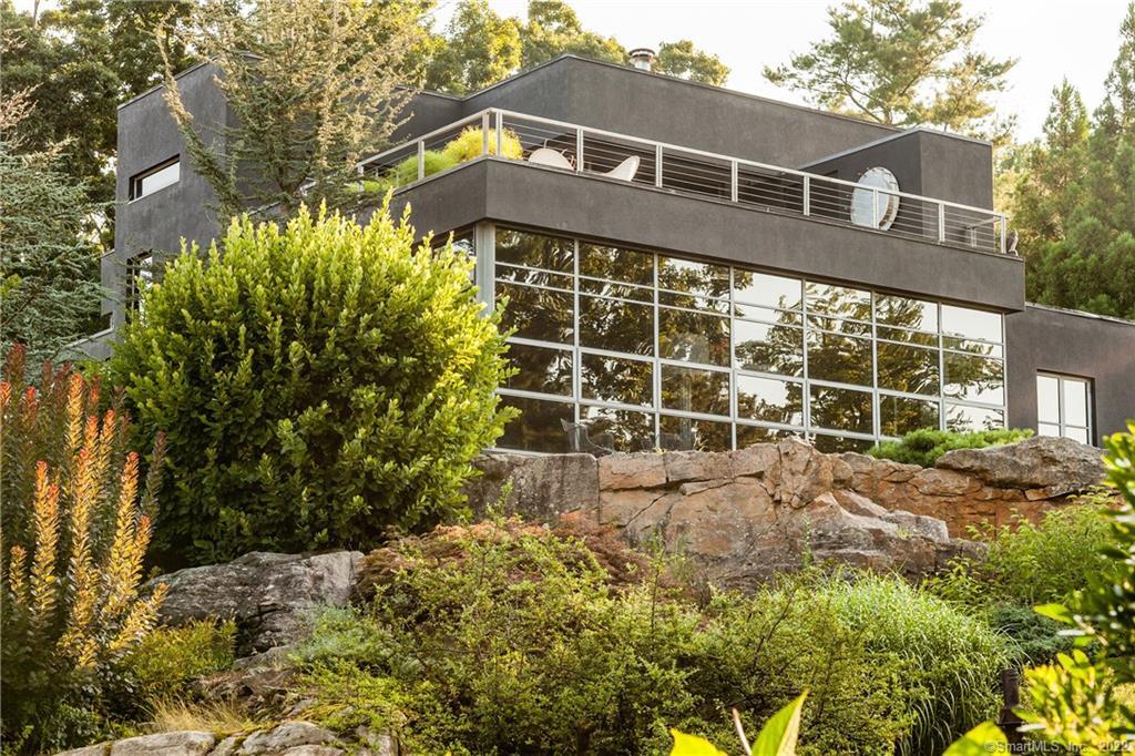 The unique form of this steel framed house emerges from a combination of extensive and mature specimen landscape and rock outcroppings. Enjoy expansive views of Long Island Sound through the custom windows with low E tinted window glass which protects your furnishings and art.