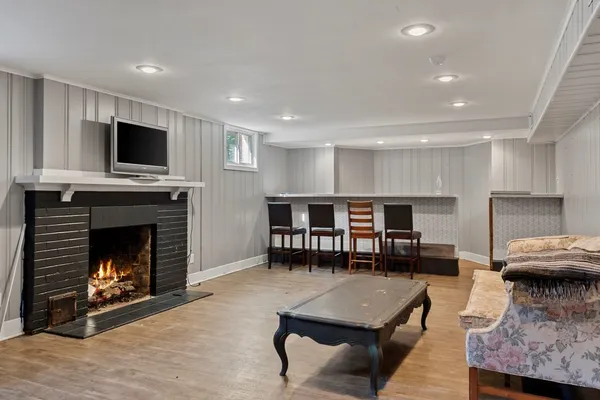 a living room with furniture a fireplace and flat screen tv