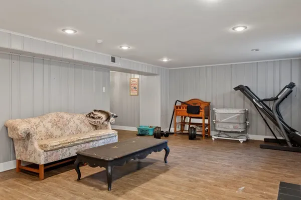 a living room with furniture gym equipment and a wooden floor