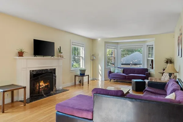 a living room with furniture a flat screen tv and a fireplace