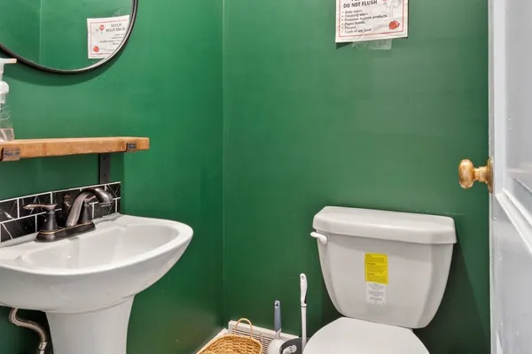 a bathroom with a toilet sink and mirror