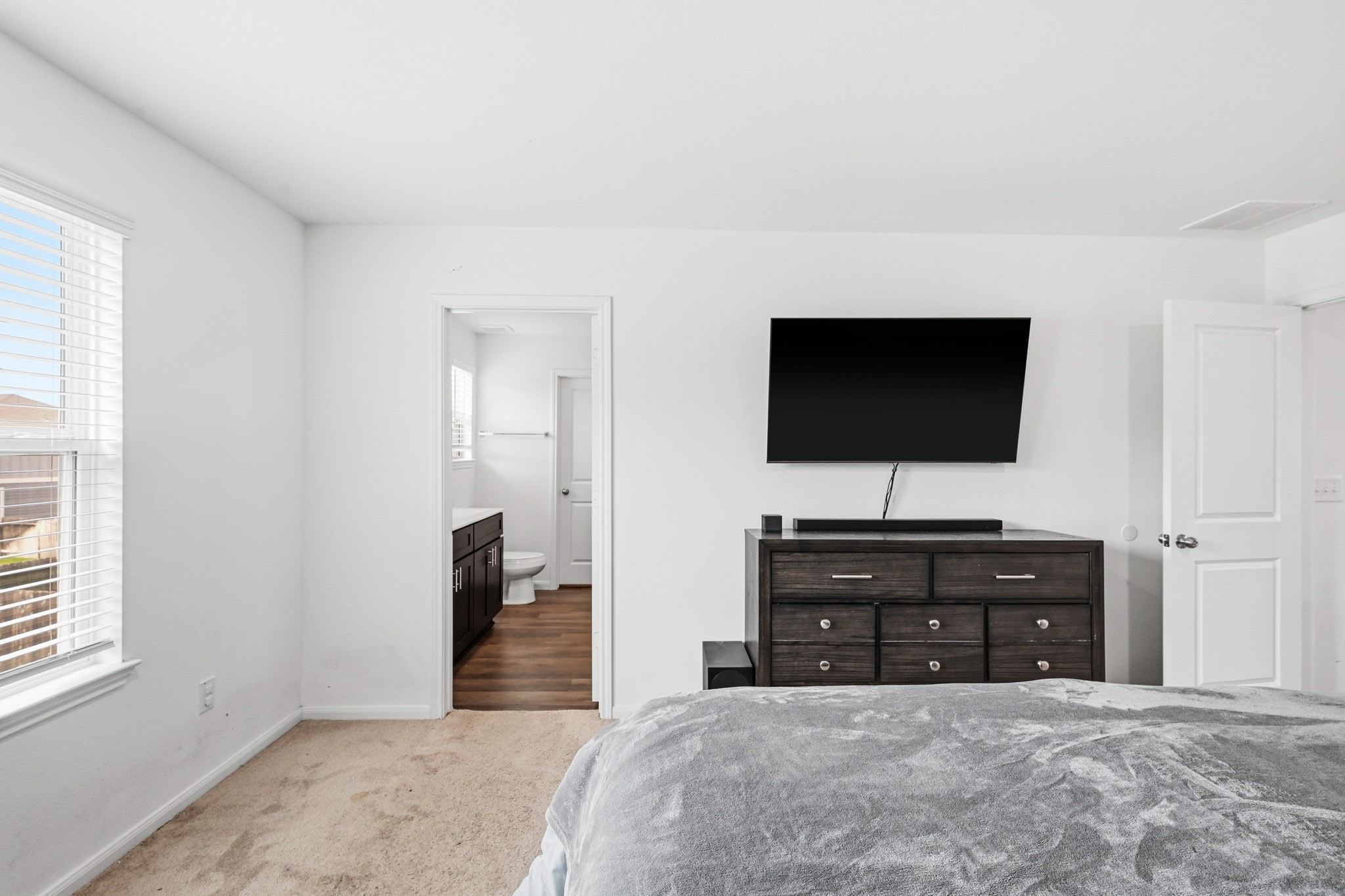 23427 Weir Box Road Hockley, TX 77447 - Photo 12 of 32 A secondary angle of the primary bedroom highlights the large window offering natural light and the seamless flow directly into the private ensuite bathroom.