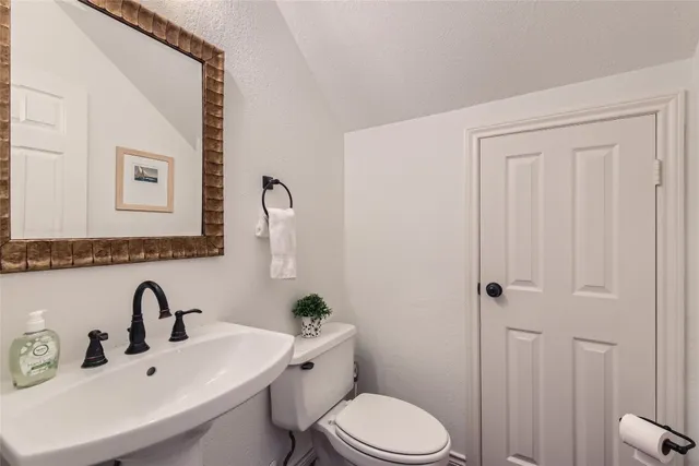 a bathroom with a sink a toilet and mirror
