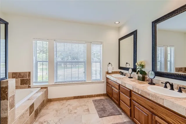 a spacious bathroom with double vanity and a large mirror