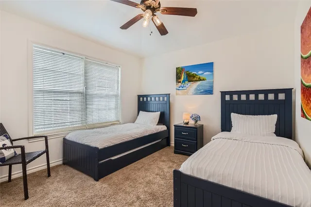 a bedroom with two beds and window