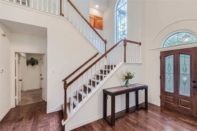 a view of staircase with lots of frames on wall and wooden floor