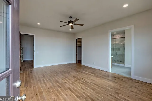 a view of a hallway with wooden floor windows and a living room