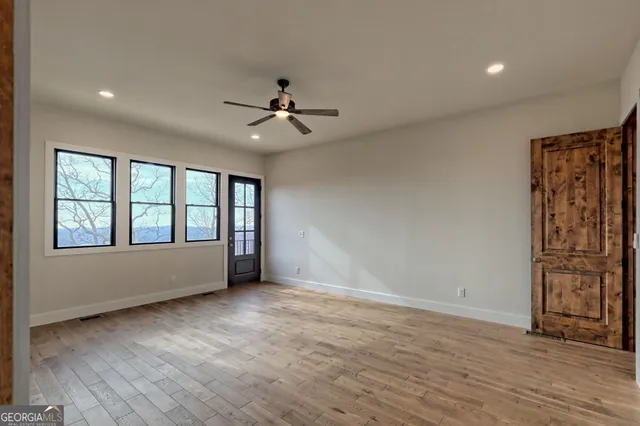 a view of a hallway with wooden floor and dining room