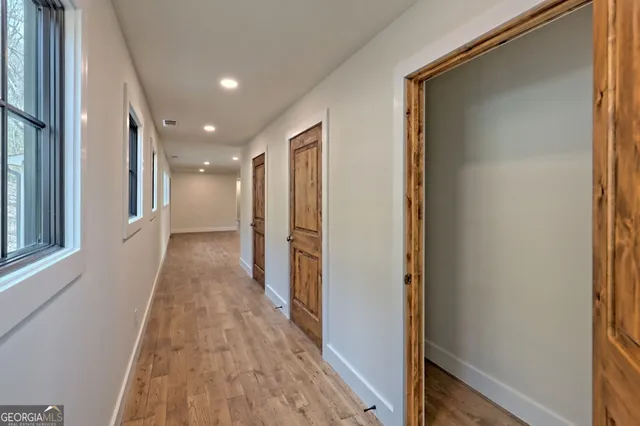 a view of a white house with large windows and a small yard