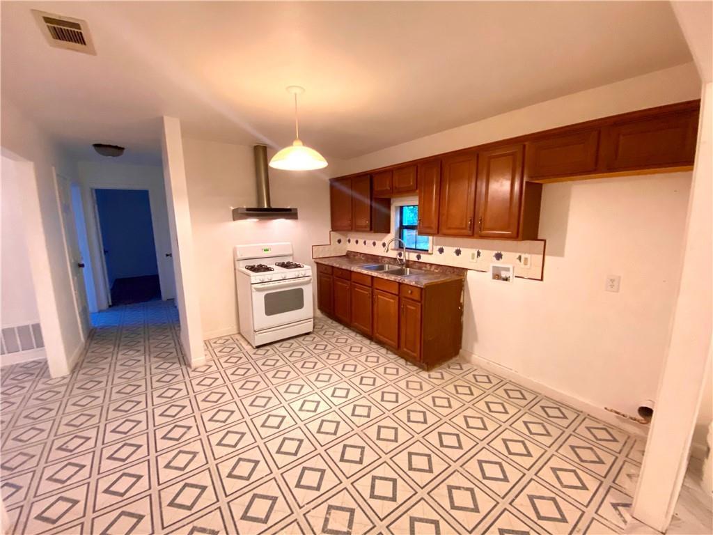 6211 Club Terrace Austin, TX 78741 - Photo 11 of 25 a kitchen with stainless steel appliances a stove a sink and a refrigerator