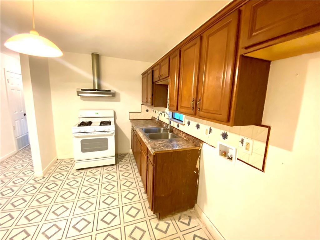 6211 Club Terrace Austin, TX 78741 - Photo 14 of 25 a kitchen with a sink a stove and a refrigerator