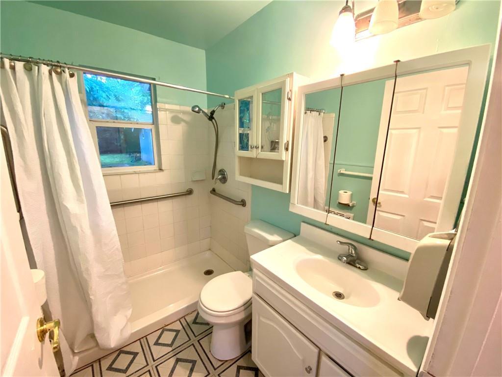 6211 Club Terrace Austin, TX 78741 - Photo 7 of 25 a bathroom with a sink a toilet a mirror and shower