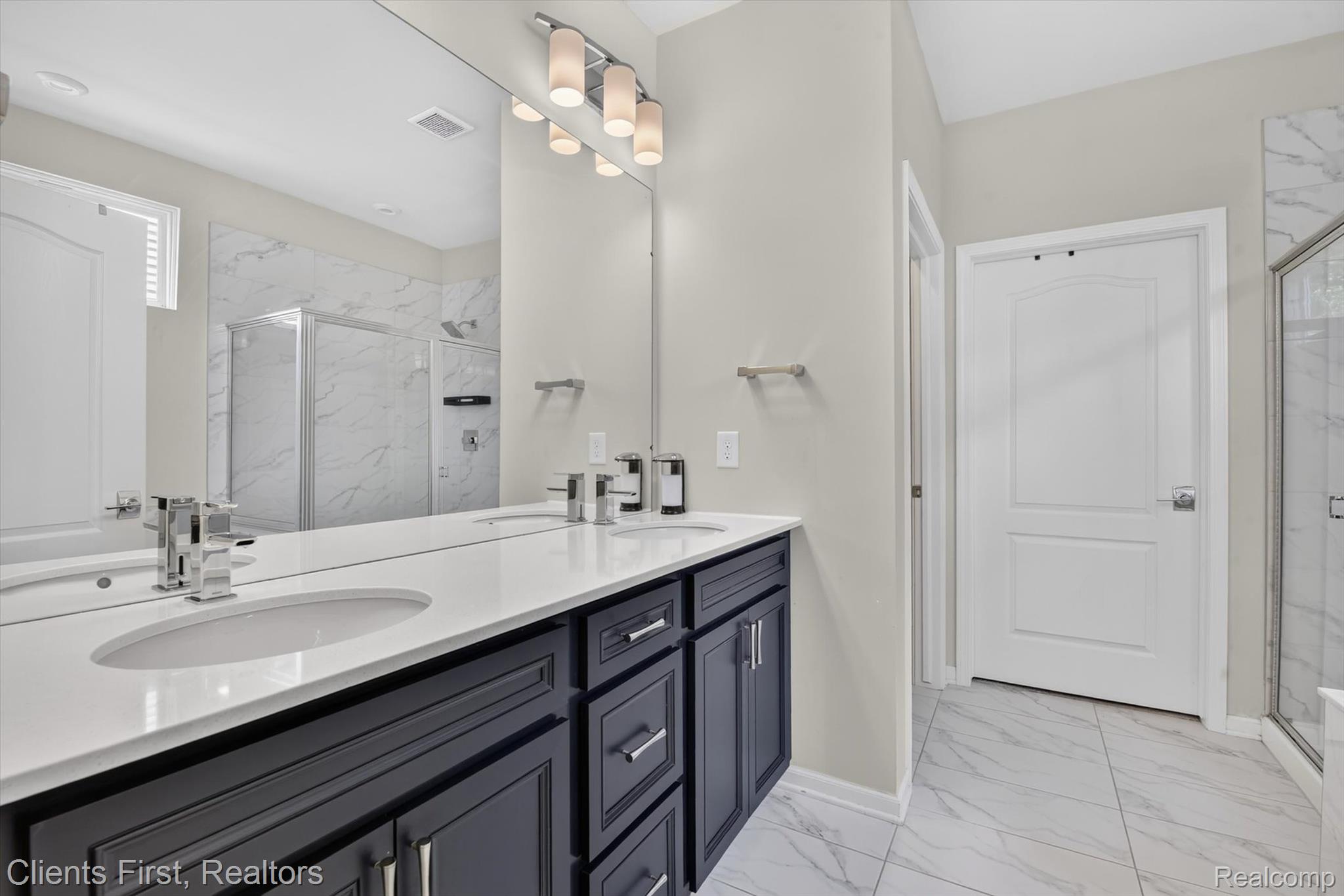 4699 Bingham Road Canton, MI 48188 - Photo 19 of 47 Dual basin vanity with dark cabinetry and chrome hardware, featuring a full-width mirror and contemporary lighting