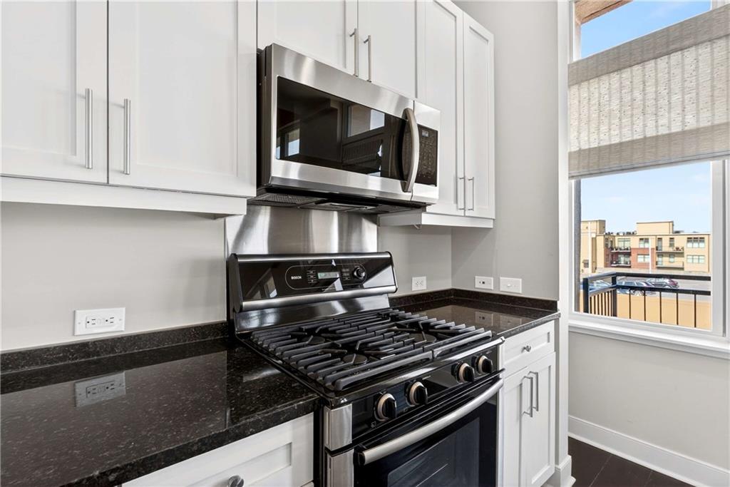 201 West Ponce De Leon Avenue, Unit 702 Decatur, GA 30030 - Photo 7 of 41 a kitchen with stainless steel appliances granite countertop a stove and a microwave