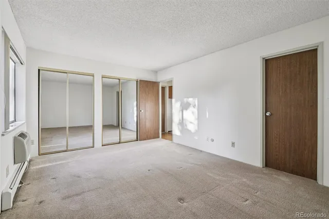 a view of an empty room with window and closet area