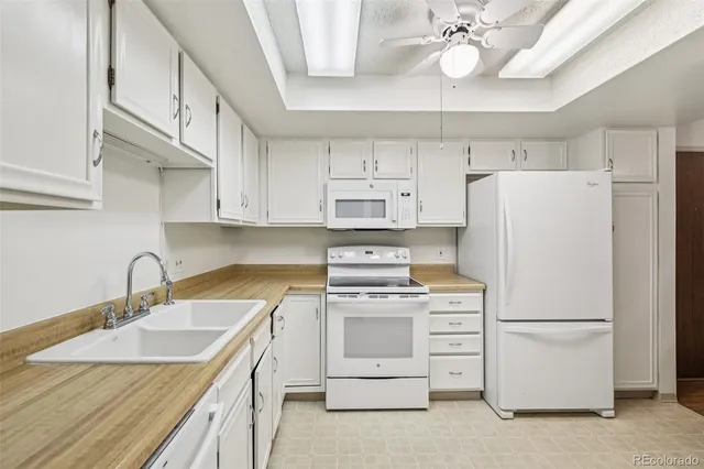 a kitchen with cabinets appliances a sink and a counter top space