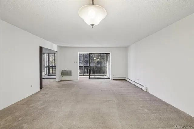 an empty room with windows and cabinet
