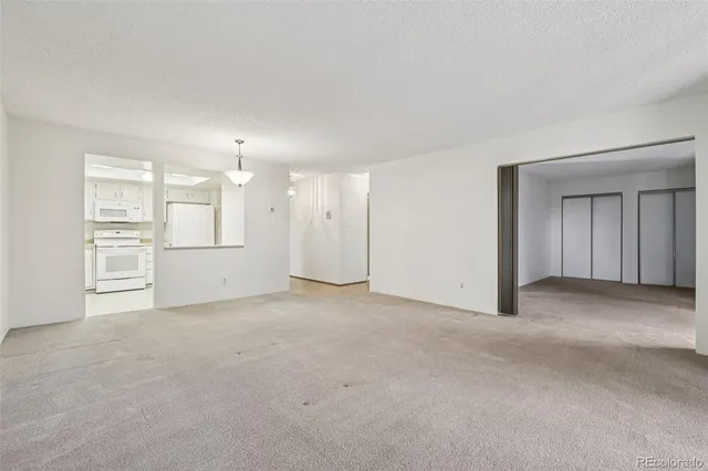 a view of an empty room with a kitchen