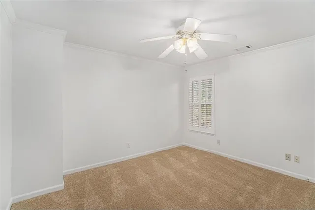 an empty room with a chandelier fan and windows